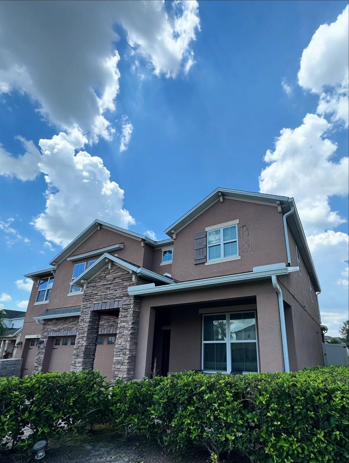 White seamless gutters and downspouts finished along the rooflines of a two-story Central Florida home
