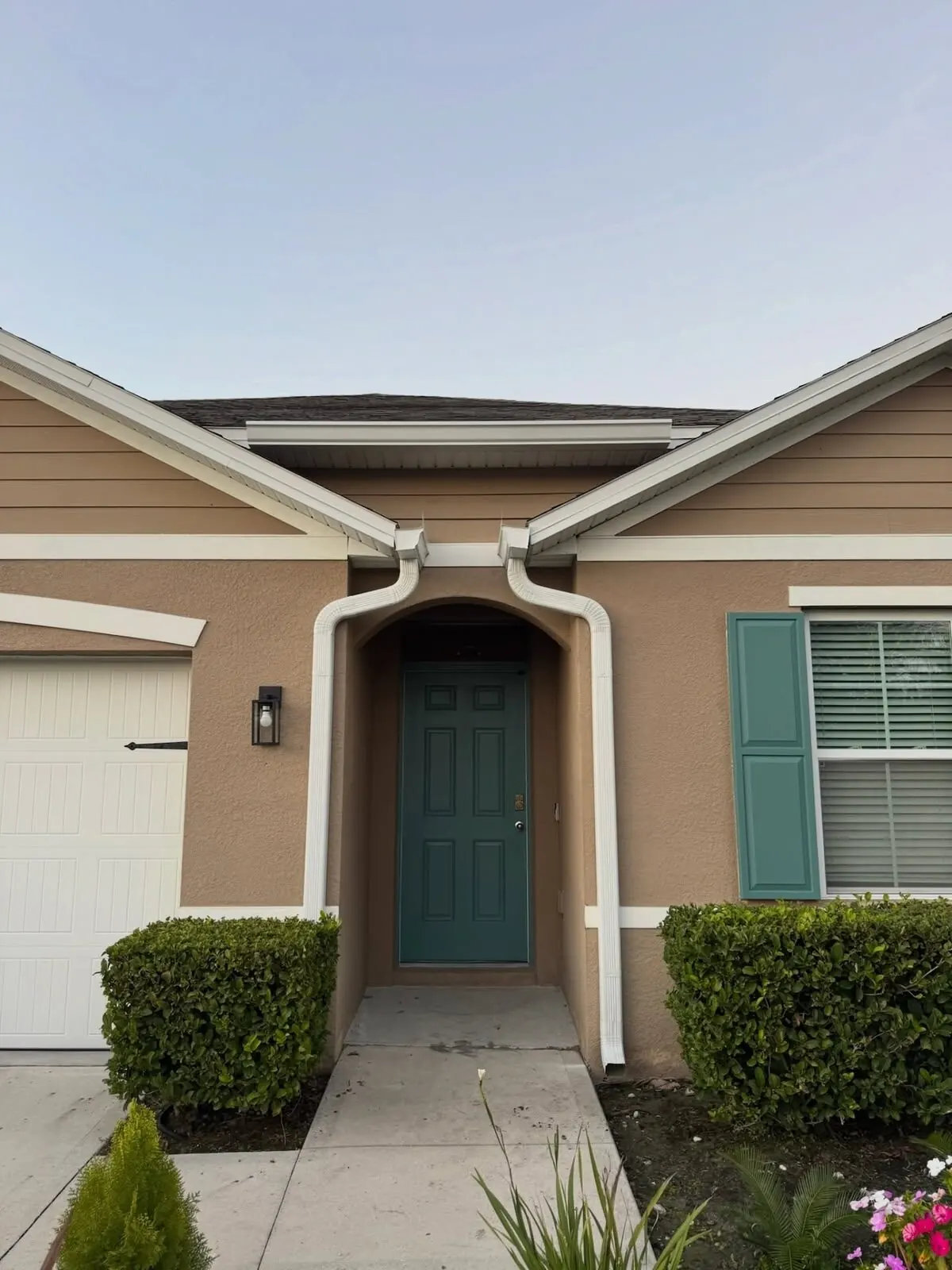 Front entry with white gutters and downspouts