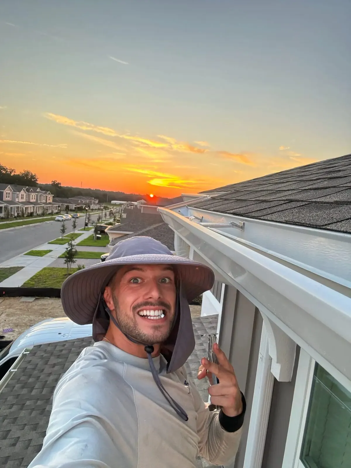 Thurler installer beside a completed gutter at sunset