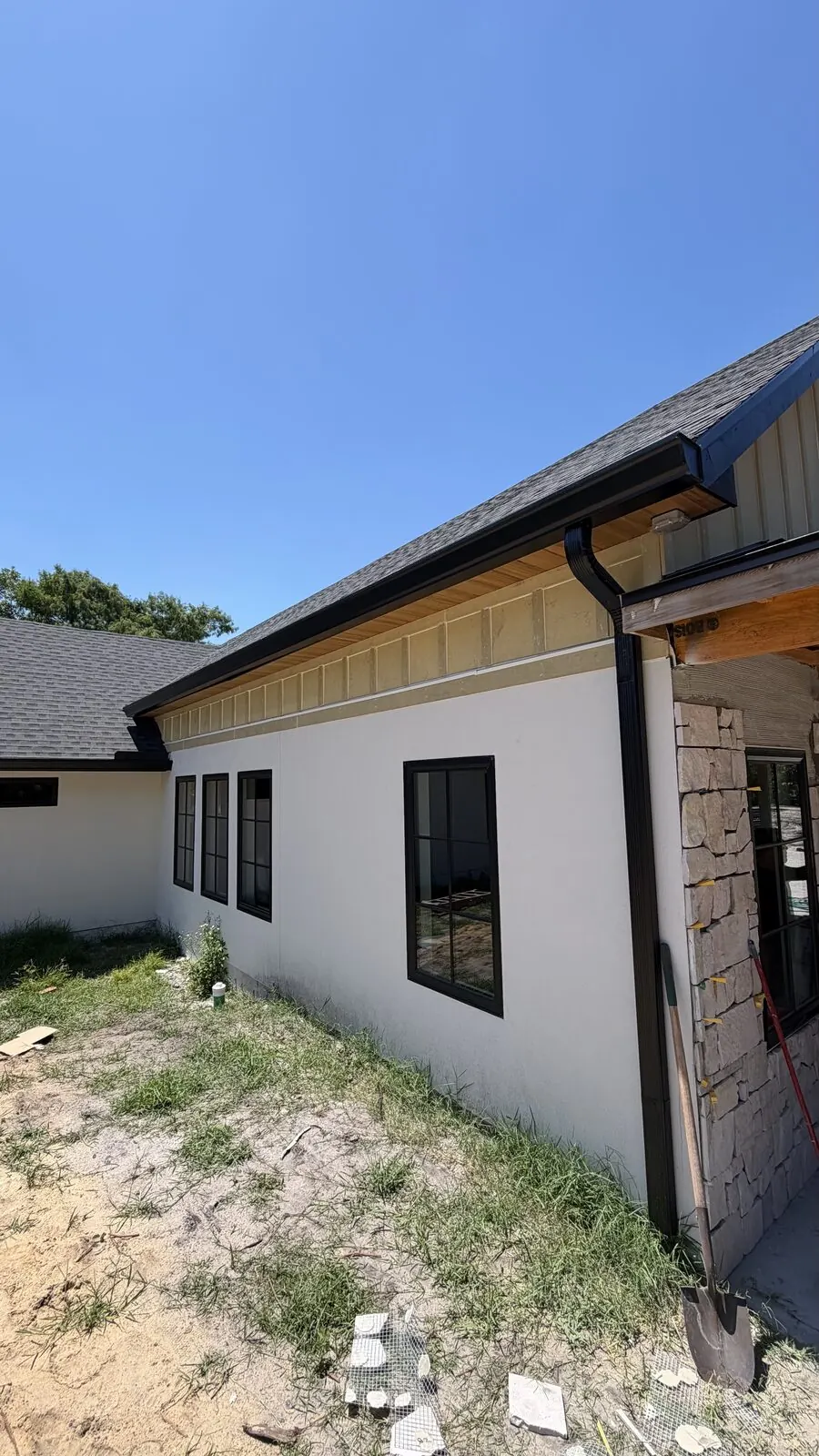 Black gutter and fascia under a warm wood soffit