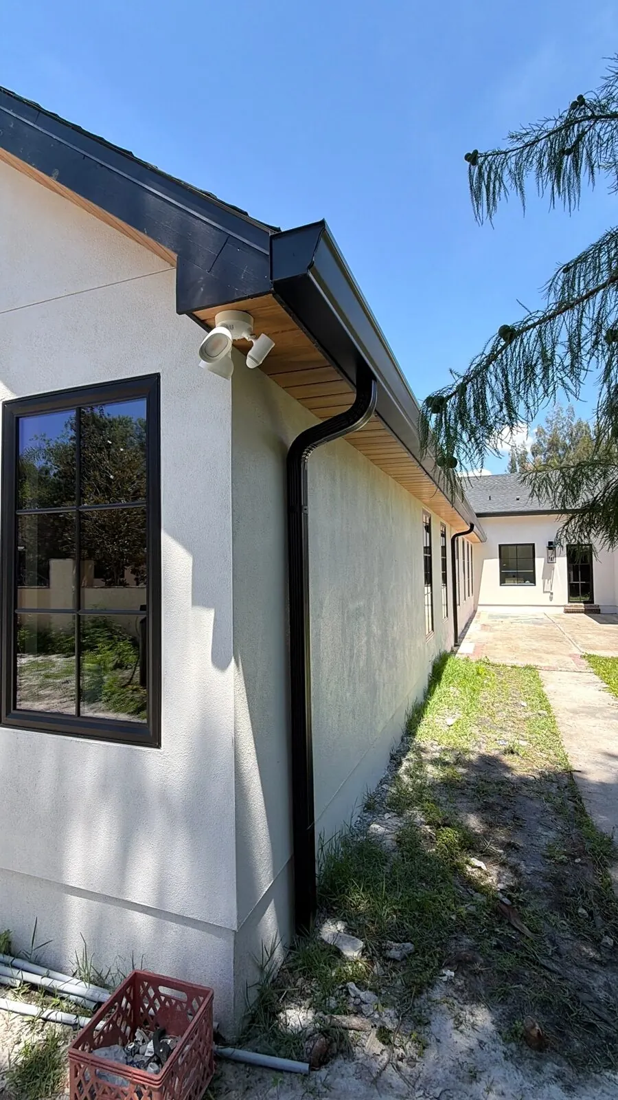Black fascia and downspout with a wood soffit