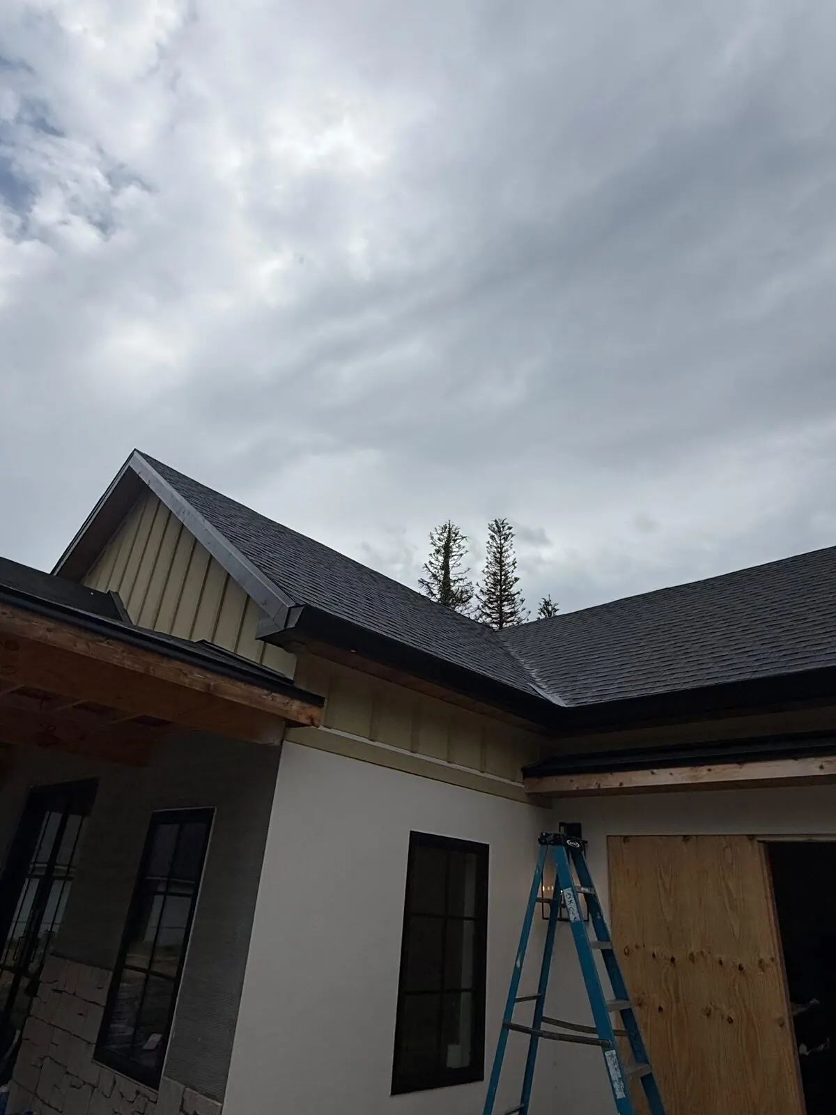 Board-and-batten gable siding in progress with a ladder