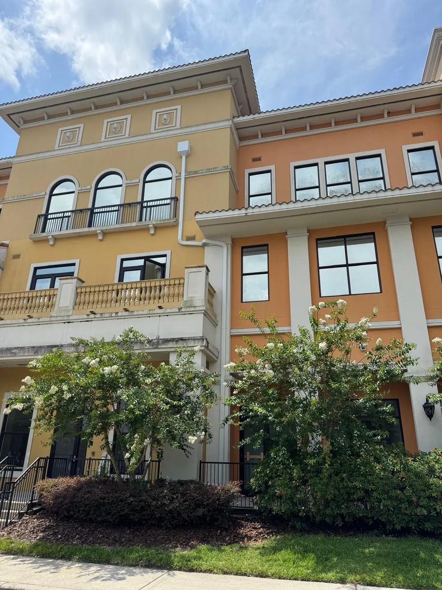 Multi-story yellow and orange commercial building with downspouts