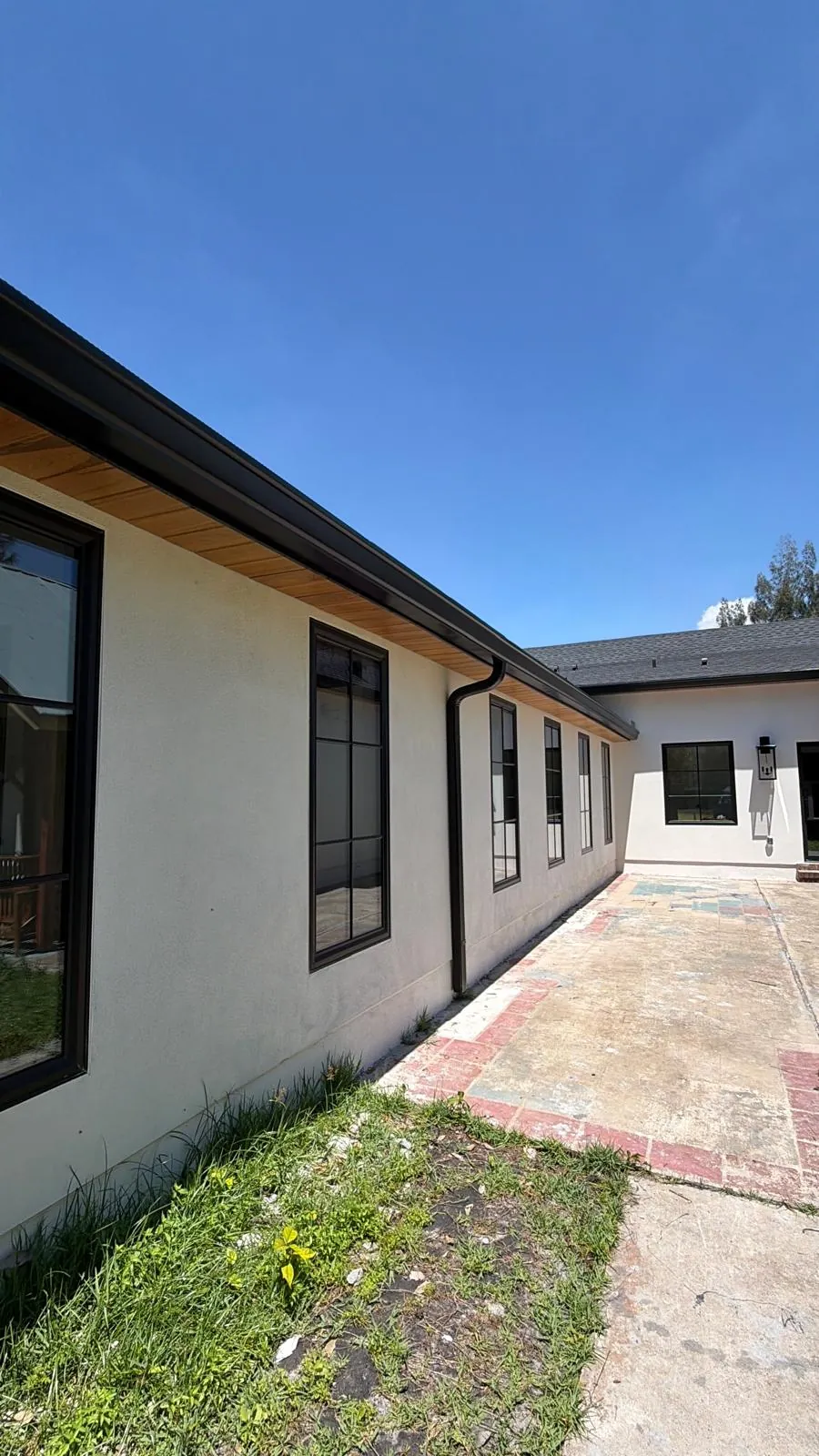 Single-story home with dark gutters under a wood soffit