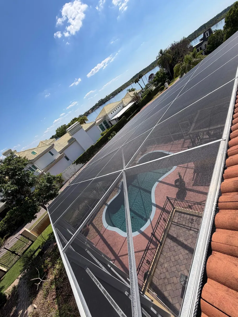 Pool screen enclosure next to a tile roof on a lakefront home