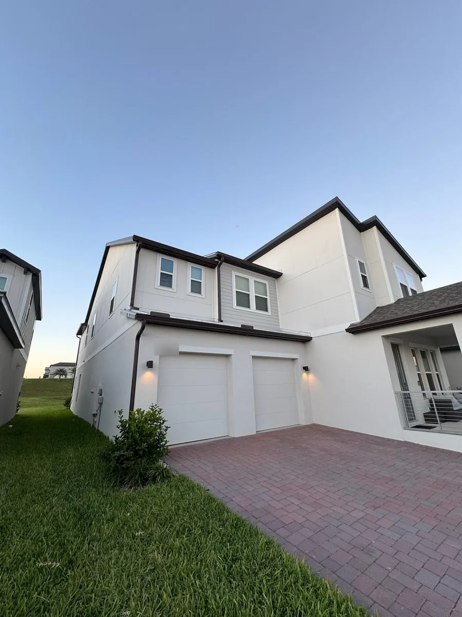 Two-story modern home with bronze gutters on every roof level