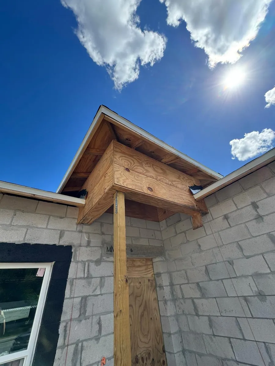 Wood framing of a new porch overhang on a block home