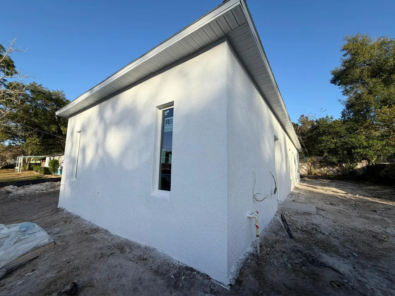 New white stucco home with vented white soffit and fascia