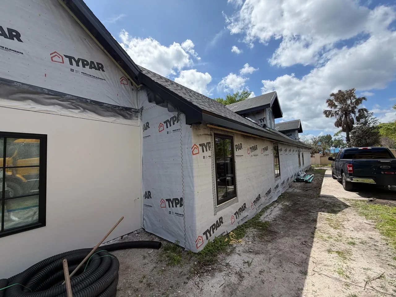 Long single-story home wrapped in house wrap before siding